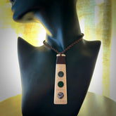 This photo shows a medium sized Toki pendant hand carved from bone with New Zealand Pounamu, Jade and Aotea Stone, Paua Shell inlay alongside; brass and silver. This is a stand out one off necklace for those who appreciate art to wear. It is provided with a cord in brown that is a fixed length with Paua Shell Toggle. We ship this piece worldwide and shipping is included in the price.